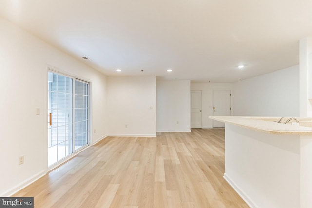 unfurnished living room featuring light wood-style floors, recessed lighting, visible vents, and baseboards