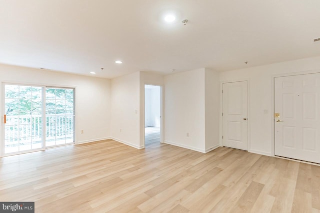 empty room featuring light wood-style flooring, baseboards, and recessed lighting