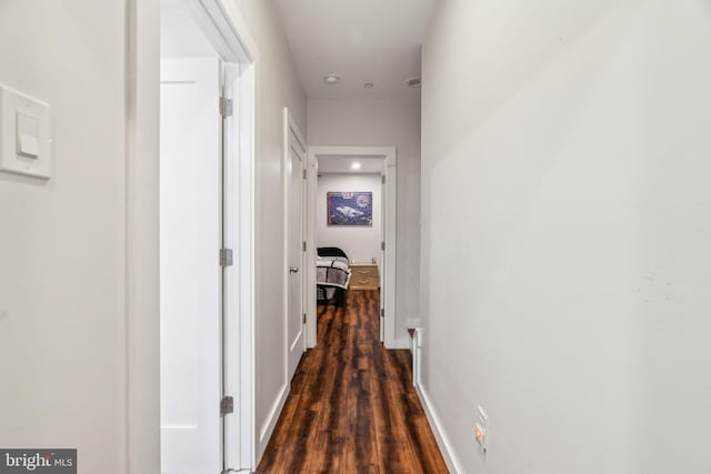 hall featuring baseboards and dark wood finished floors