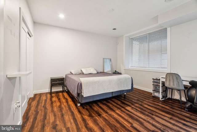 bedroom with baseboards, wood finished floors, and recessed lighting