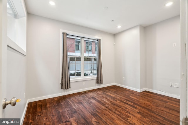 empty room with visible vents, baseboards, dark wood finished floors, and recessed lighting