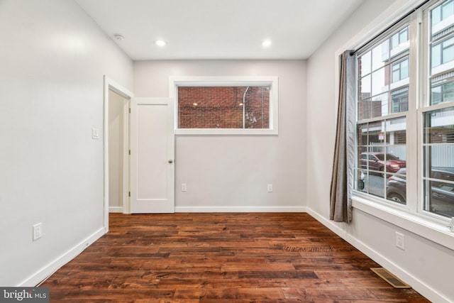 unfurnished room with recessed lighting, wood finished floors, visible vents, and baseboards