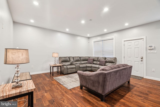 living room featuring dark wood-type flooring, recessed lighting, and baseboards