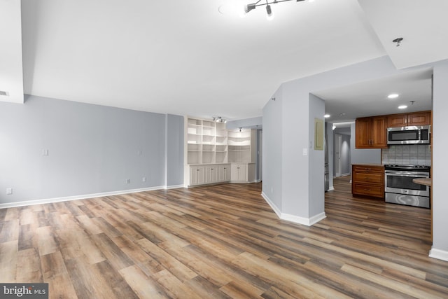 unfurnished living room with recessed lighting, baseboards, and wood finished floors