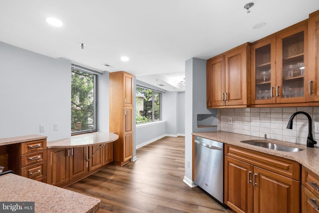 kitchen featuring a sink, light stone countertops, brown cabinets, and dishwasher