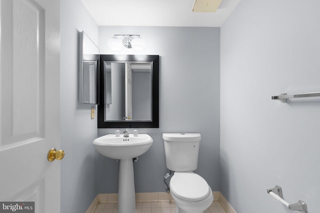 bathroom featuring toilet, baseboards, and tile patterned floors