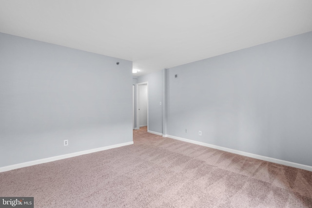 unfurnished room with carpet flooring and baseboards