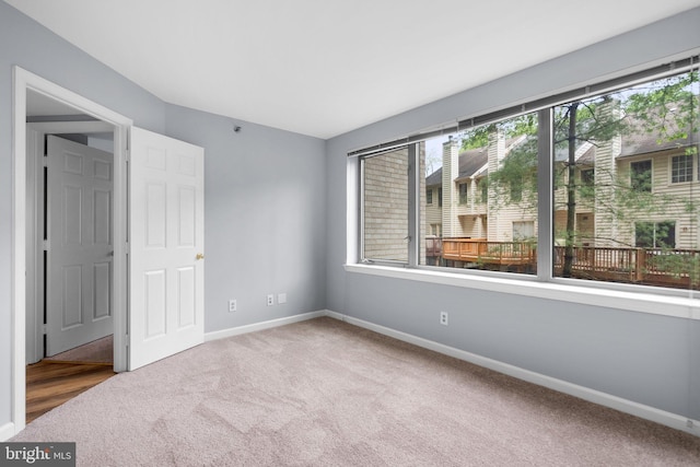 unfurnished room featuring baseboards and carpet flooring