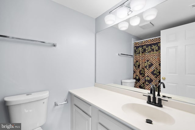 full bathroom featuring a shower with shower curtain, visible vents, vanity, and toilet