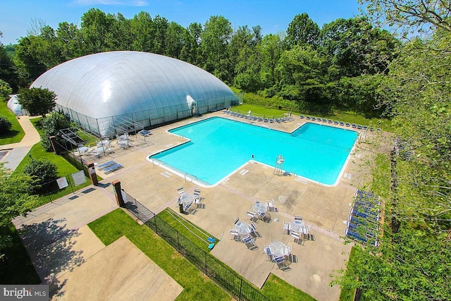 community pool featuring fence and a patio