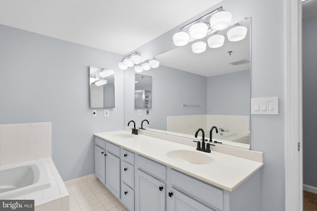 full bath with double vanity, tile patterned floors, a sink, and baseboards