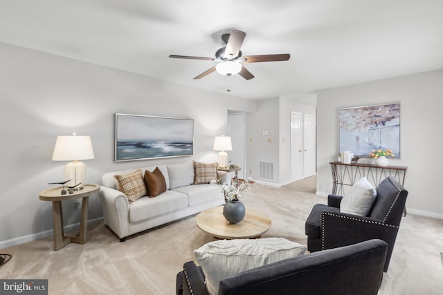 living area with baseboards, visible vents, ceiling fan, and carpet flooring