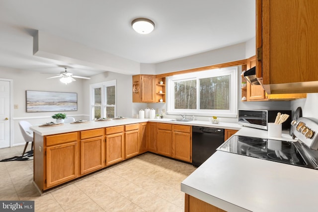 kitchen with black dishwasher, light countertops, and a peninsula