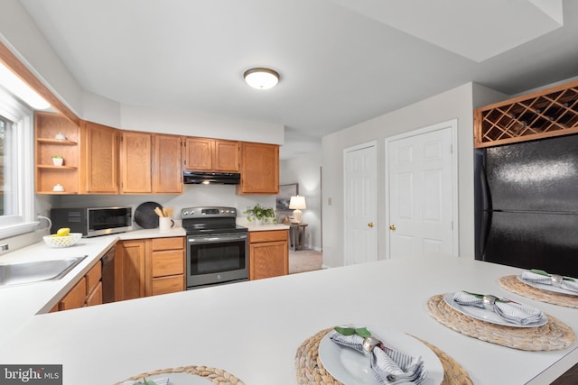 kitchen featuring under cabinet range hood, stainless steel appliances, a sink, light countertops, and open shelves