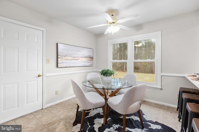 dining area featuring light tile patterned floors, ceiling fan, and baseboards