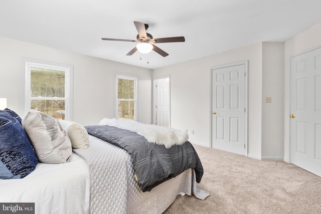 carpeted bedroom with baseboards and a ceiling fan