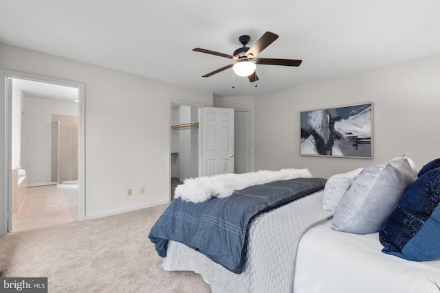 bedroom with baseboards, connected bathroom, ceiling fan, carpet floors, and a closet