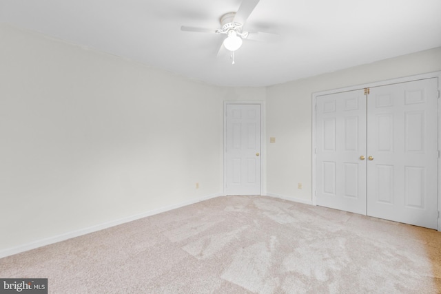 unfurnished bedroom featuring a ceiling fan, a closet, baseboards, and carpet flooring