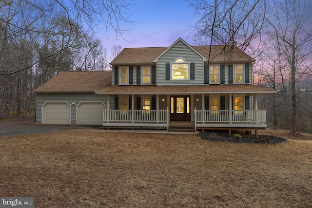 view of front facade featuring a garage, driveway, a porch, and a shingled roof