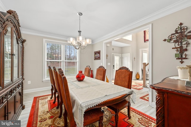 dining area with light wood-style floors, a chandelier, and crown molding