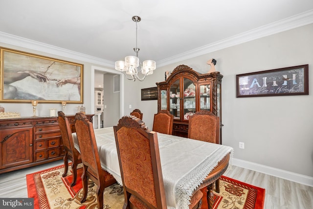 dining space featuring baseboards, light wood-style floors, an inviting chandelier, and ornamental molding