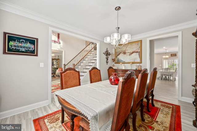 dining space featuring a notable chandelier, light wood-style flooring, and stairs