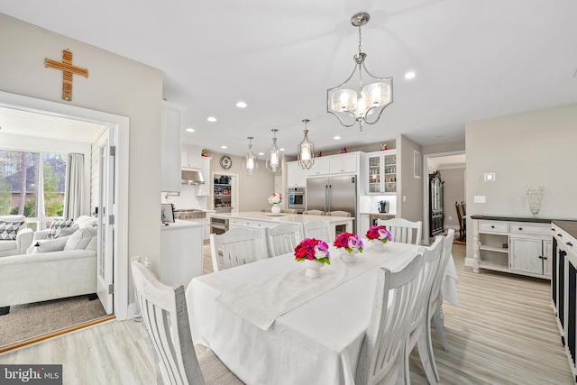 dining room featuring recessed lighting, a notable chandelier, and light wood-style floors