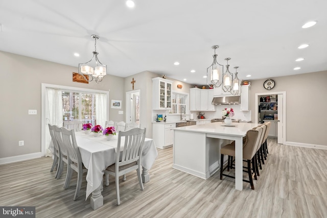 dining room featuring light wood-style flooring, recessed lighting, and baseboards