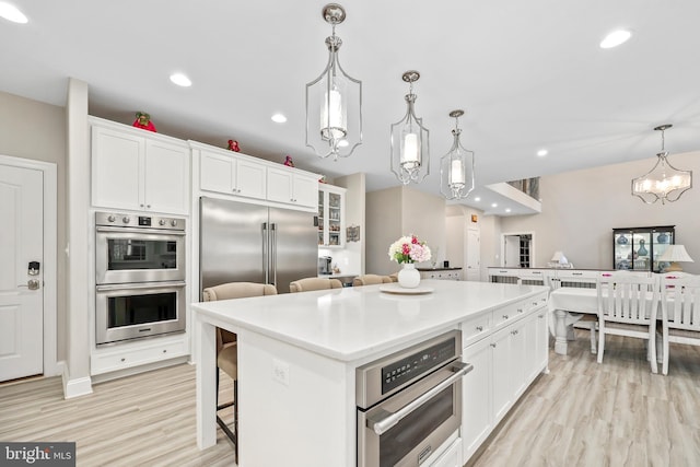 kitchen with recessed lighting, appliances with stainless steel finishes, a center island, and white cabinetry