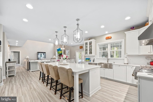 kitchen with a healthy amount of sunlight, a center island, light countertops, and a sink