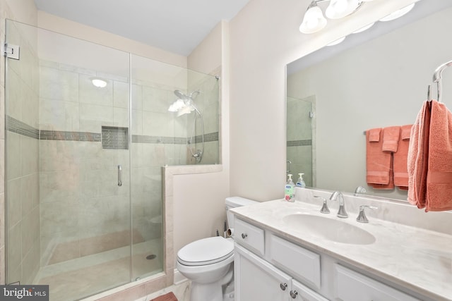 bathroom with vanity, toilet, and a stall shower