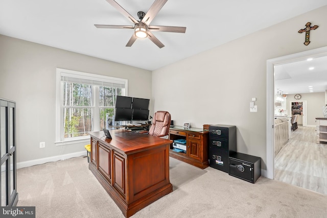 office featuring light colored carpet, baseboards, and ceiling fan