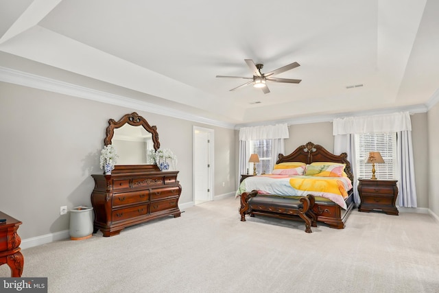 bedroom featuring visible vents, multiple windows, baseboards, and a tray ceiling