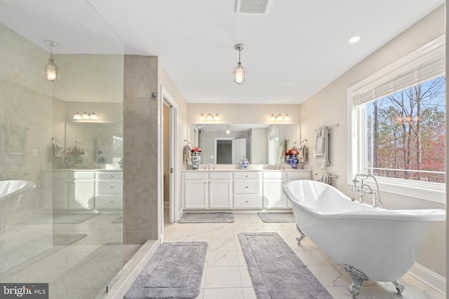 bathroom with visible vents, double vanity, a sink, a freestanding bath, and marble finish floor