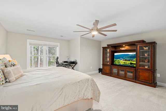 carpeted bedroom featuring a ceiling fan, visible vents, and baseboards