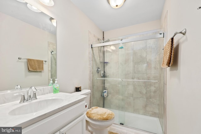 bathroom with vanity, toilet, and a shower stall