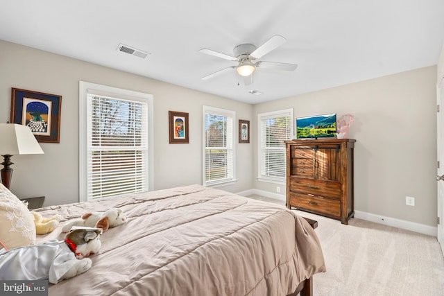 carpeted bedroom with visible vents, a ceiling fan, and baseboards