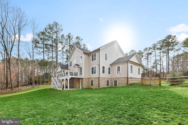 rear view of house featuring stairway, a fenced backyard, a lawn, and a wooden deck