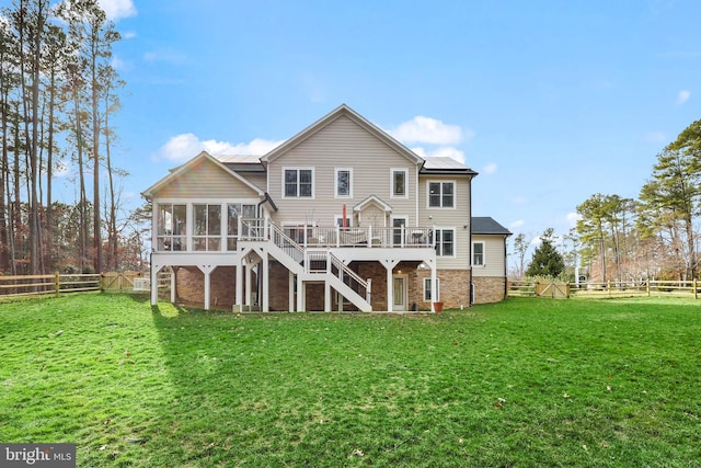 rear view of property featuring stairway, a fenced backyard, a lawn, and a sunroom