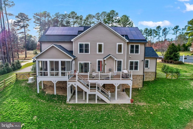 back of house featuring stairway, a wooden deck, a sunroom, a patio, and a gate