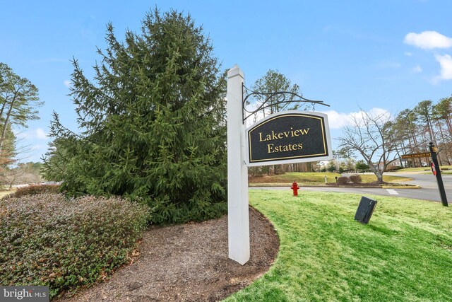 community / neighborhood sign with a yard