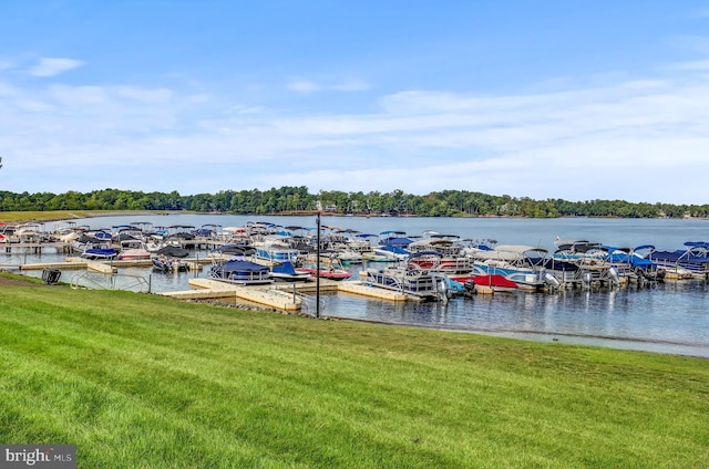 view of dock with a yard and a water view