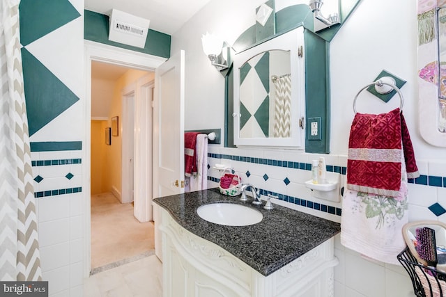 full bathroom featuring tile walls and vanity