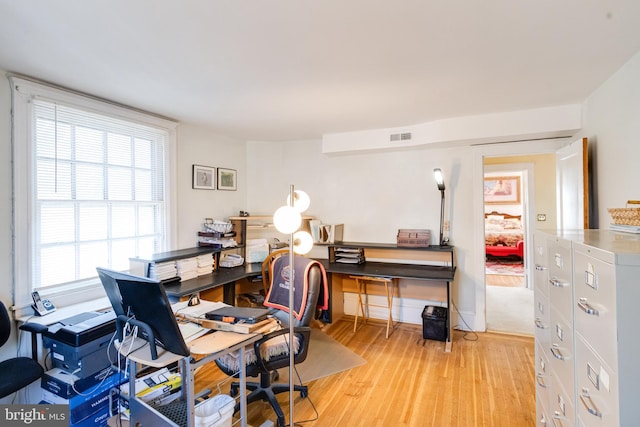 home office with visible vents, light wood-style flooring, and baseboards