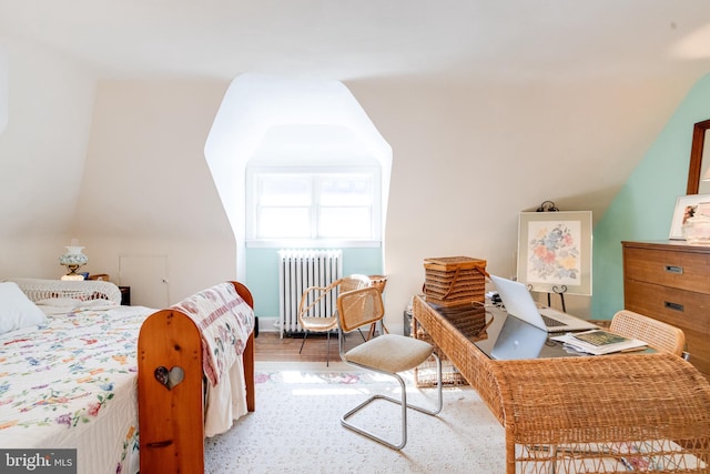 bedroom with radiator heating unit and wood finished floors