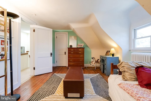 bedroom featuring wood finished floors and radiator