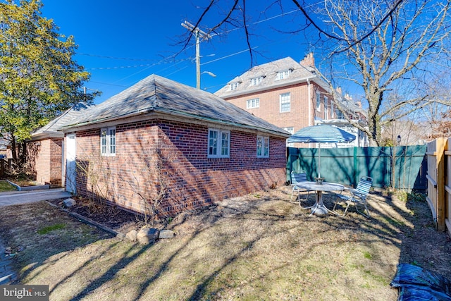 back of property featuring brick siding and a fenced backyard