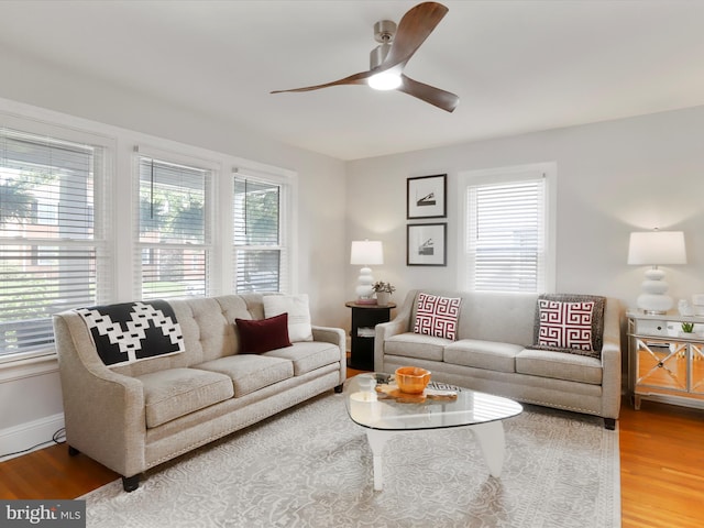 living area featuring ceiling fan, baseboards, and wood finished floors