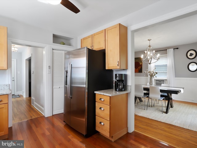 kitchen featuring dark wood-style floors, light stone counters, stainless steel refrigerator with ice dispenser, cooling unit, and ceiling fan with notable chandelier