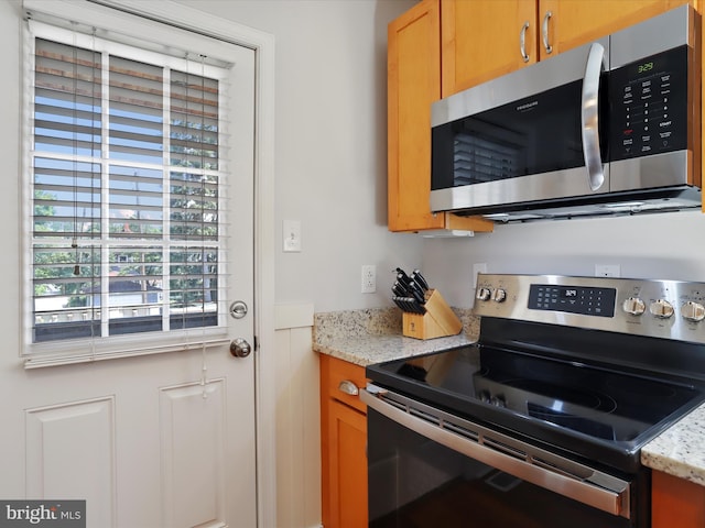 kitchen with appliances with stainless steel finishes and light stone counters